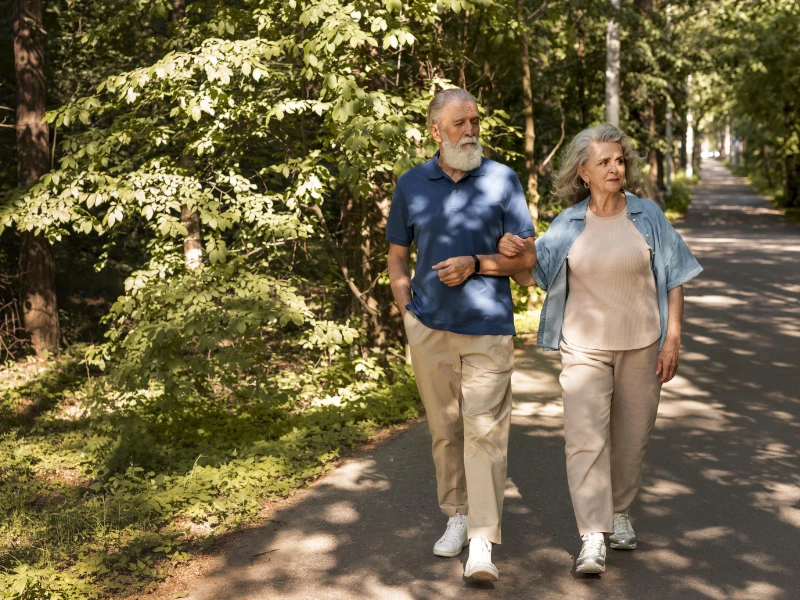 Un couple de seniors se baladant en forêt
