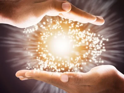 Halo de lumière entouré de deux mains